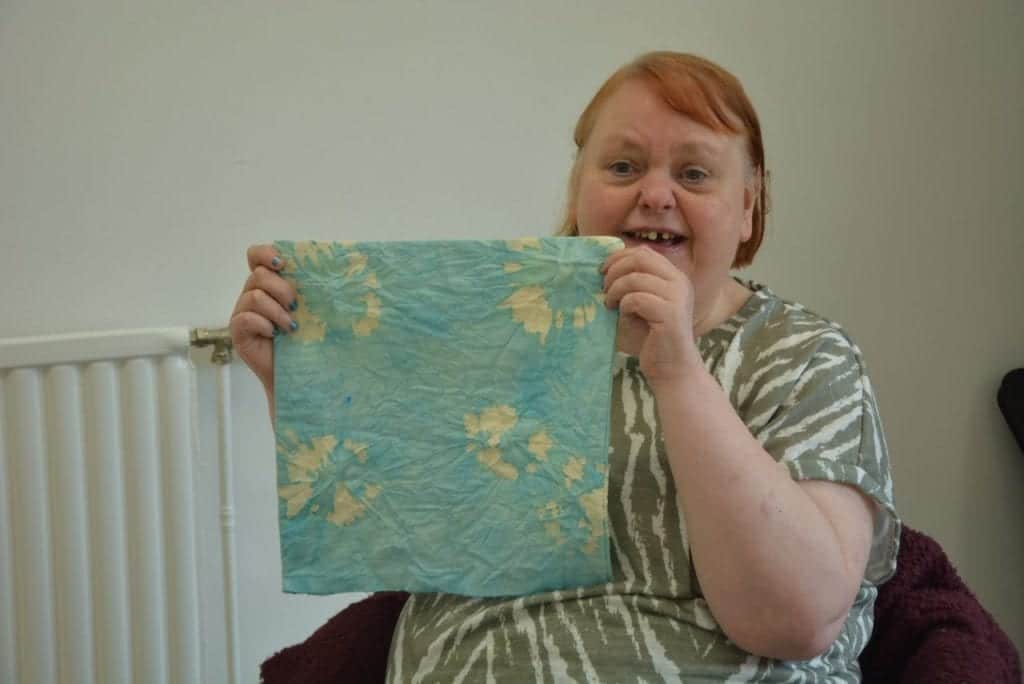 Weaving Magic at Prospect House 2 A Pure client holds up a duck egg blue tie-dyed cushion cover
