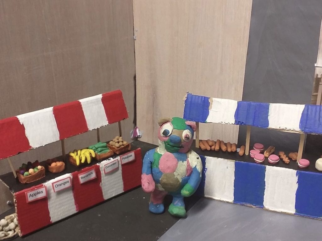 Animated Tour of London with Fred and Firestorm 5 Plasticene Fred by a carboard animation prop of a fruit stall.
